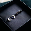 Crescent Black Moon Stud Earrings, crafted with utmost precision from sterling silver and adorned with natural rainbow moonstone by moonique