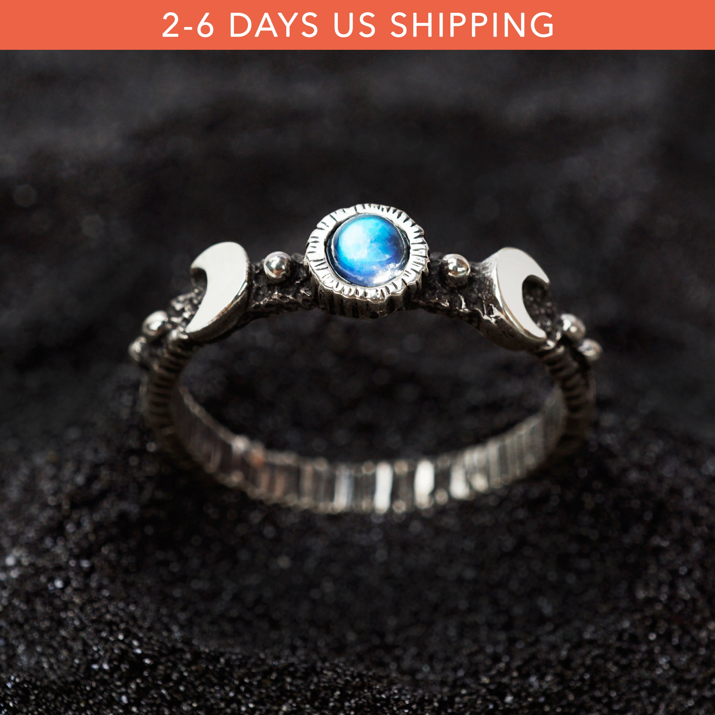 Silver moon phases moonstone ring . A silver ring with a round blue moonstone centerpiece. The ring has a textured band and a polished finish.