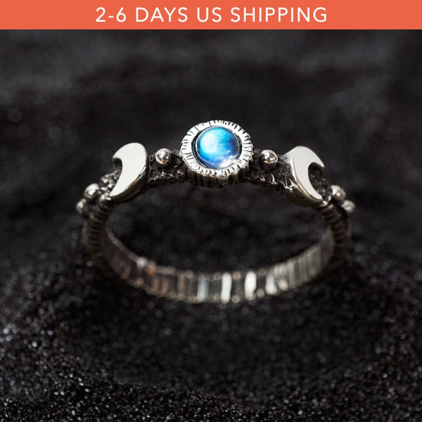 Silver moon phases moonstone ring . A silver ring with a round blue moonstone centerpiece. The ring has a textured band and a polished finish.
